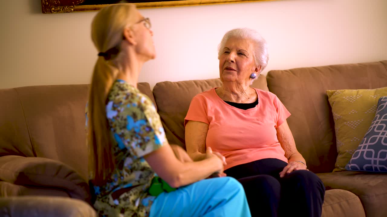 Home healthcare greets elderly woman in her living room