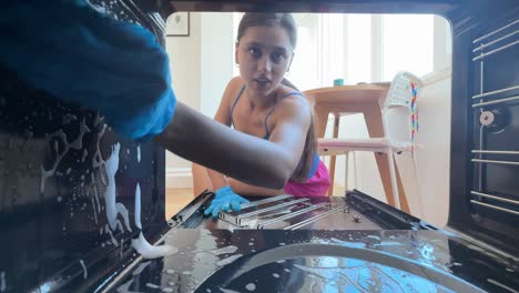 woman cleaning a dirty oven