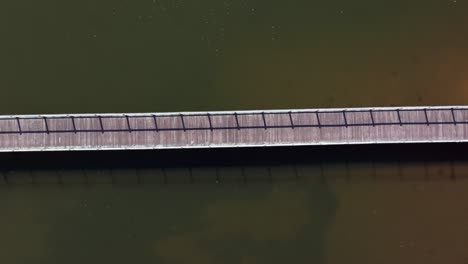 a high angle top down view of a wooden pier on oyster bay, long island on a sunny day