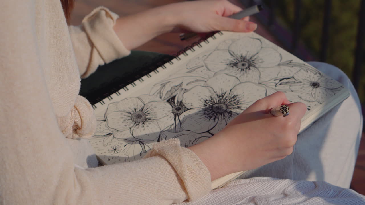 mujer dibujando flores en un cuaderno