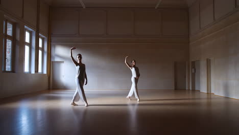 two dancers performing contemporary dance in a spacious studio