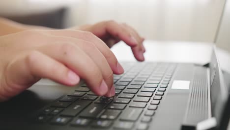 detail of male hands working on laptop