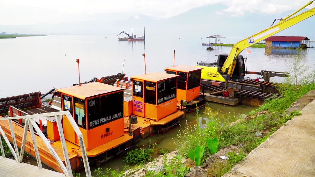 준설선과 굴삭기가 호수 항구에 주차되어 있습니다.