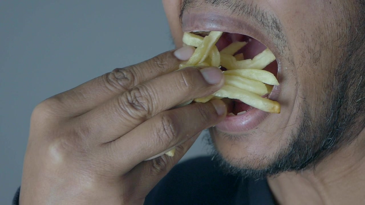 Close-up of a Man Eating French Fries
