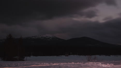 schneebedeckte berglandschaft mit dunklen wolken