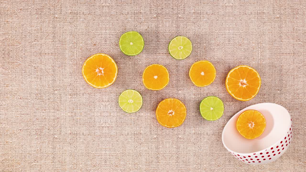 White bowl and moving slices of orange and lime. Stop motion
