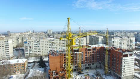 construction of building in winter. tall buildings under construction with cranes