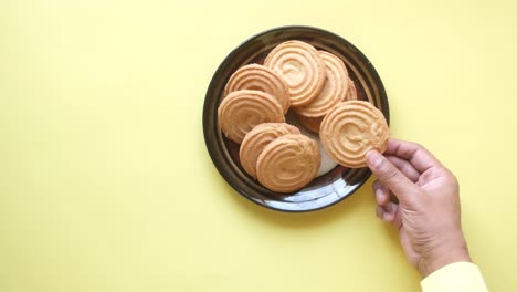 hand reaching for a cookie on a plate
