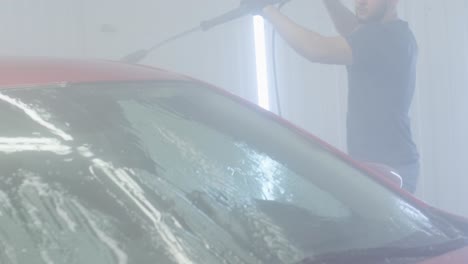 car washing cleaning with foam and high pressured water. red car