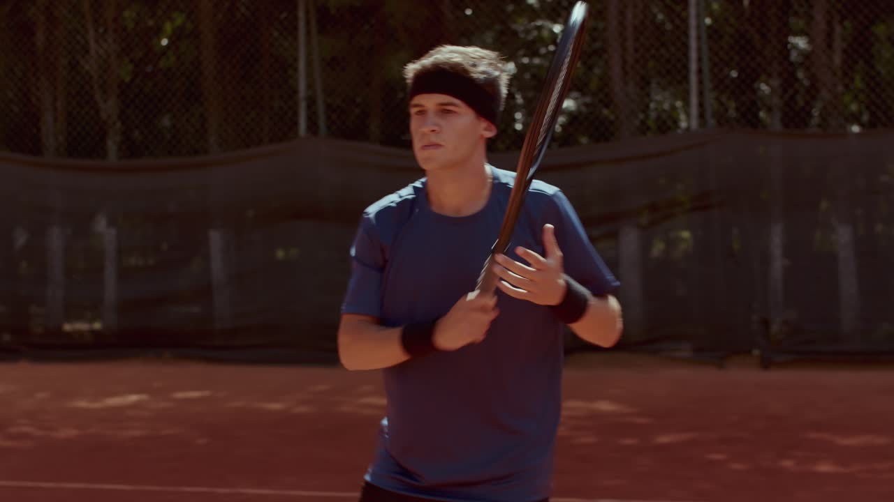 Male Tennis Player on a Clay Court Holding a Racket