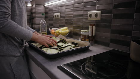 Woman-uses-hands-to-coat-sliced-eggplants-evenly-with-seasoning