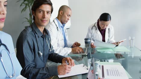 Young-doctors-sitting-at-a-table-working-together-4k