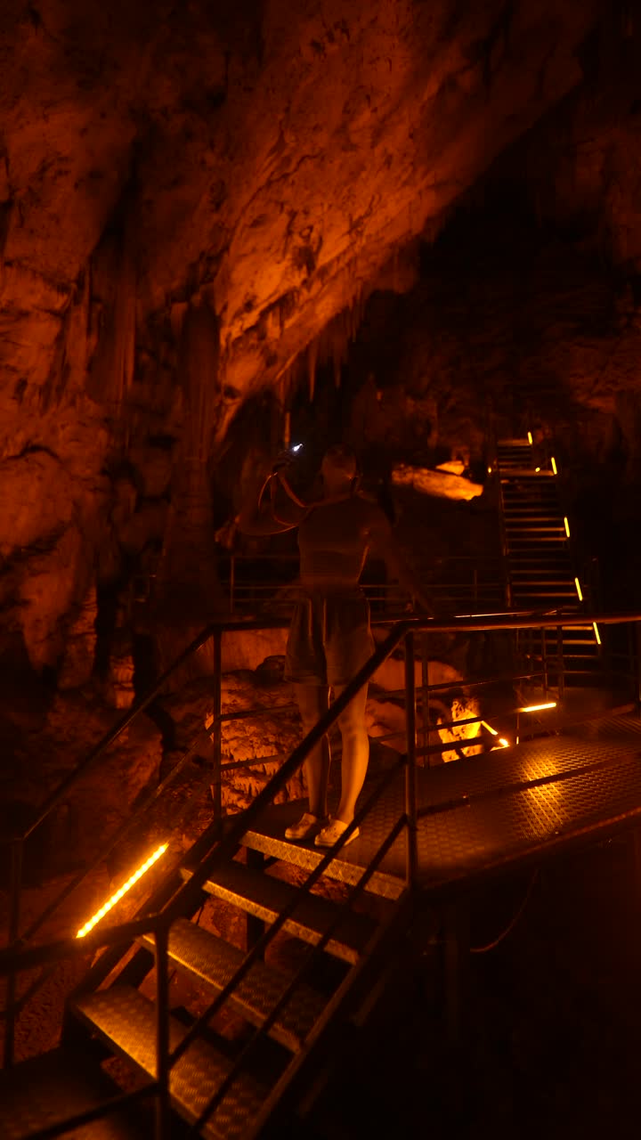 Woman exploring a cave at night