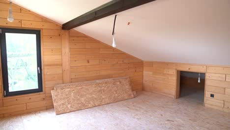 upper wooden attic room with slanted ceiling and construction materials