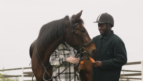 dos personas acariciando un caballo 1