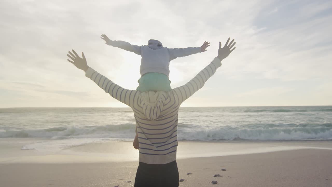 해가 지는 해변에서 피기백 여성을  ⁇ 고 있는 히스패닉 남자의 뒷면
