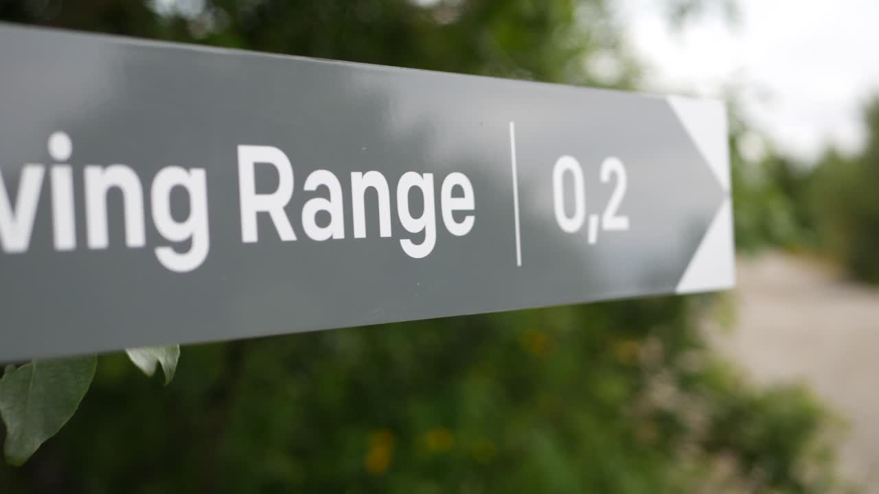 A signpost showing the way to the driving range on a golf course