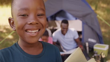 Child-smiling-at-camera-in-front-of-a-tent