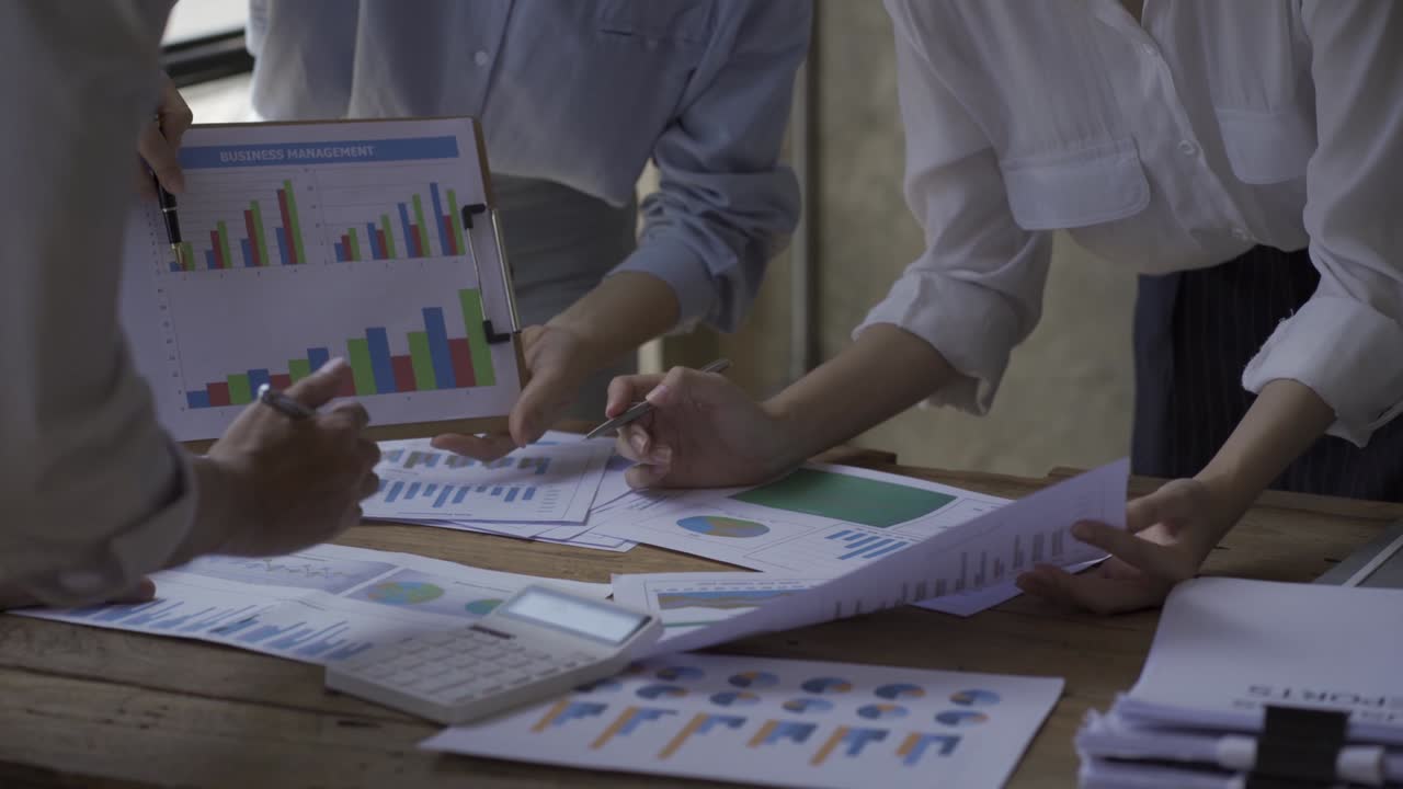 Felice donna d'affari asiatica in riunione di squadra con i colleghi per un brainstorming su progetti, finanza, grafici e documenti. Lavorano insieme per una pianificazione strategica di successo, godendosi il lavoro di squadra in ufficio.