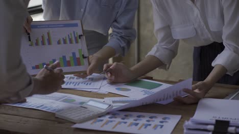 happy asian business woman team meeting brainstorm coworkers project finance graph document work together strategic planning for success enjoy working as a team in the office.
