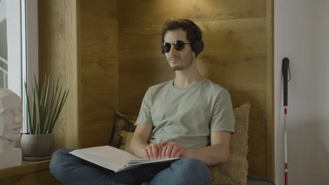 caucasian young man with headphones touching a book