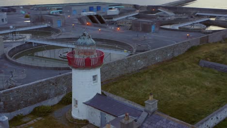 verbluffende luchtbeelden van de iconische vuurtoren van mutton island en de afvalwaterzuiveringsinstallatie in de stad galway, die in een adembenemende cirkelvormige beweging ronddraaien