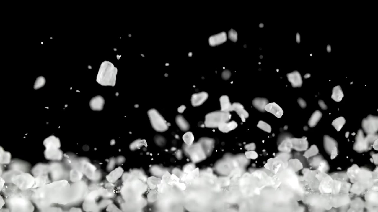 White Salt Crystals Falling on Black Background in Slow Motion