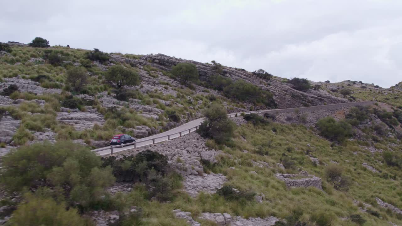 coche negro conduciendo en coll dels reis, un paso de montaña ubicado en mallorca, aérea