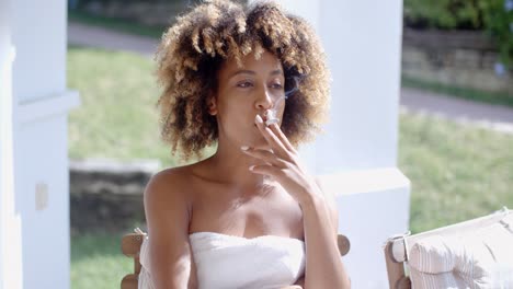 mujer sentada en la terraza y fumando