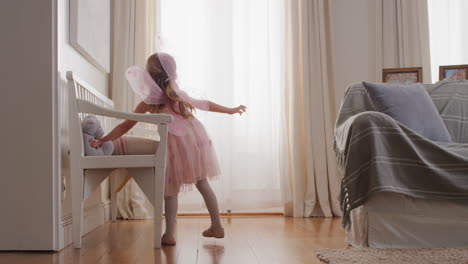 cute little girl dancing playfully pretending to be ballerina happy child having fun playing dress up wearing ballet costume with fairy wings at home 4k