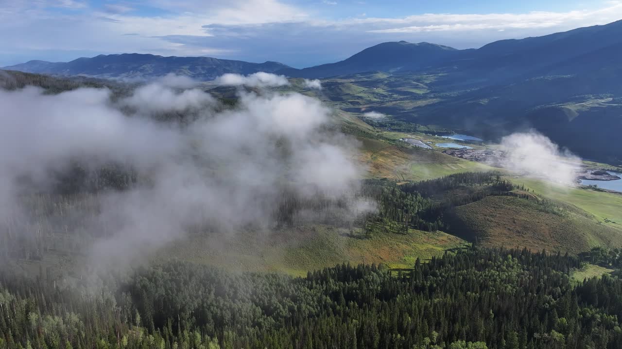 nubes y niebla atmosférica sobre los exuberantes bosques de pinos temprano en la mañana colorado transporte aéreo pan 4k