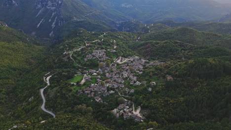 aerial establishing view of papigo village nestled in lush green zagori landscape, surrounded by mountains