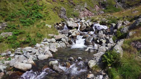 Corriente-De-Montaña-Que-Fluye-Rápidamente-En-Cascada-Por-La-Ladera-De-Una-Montaña