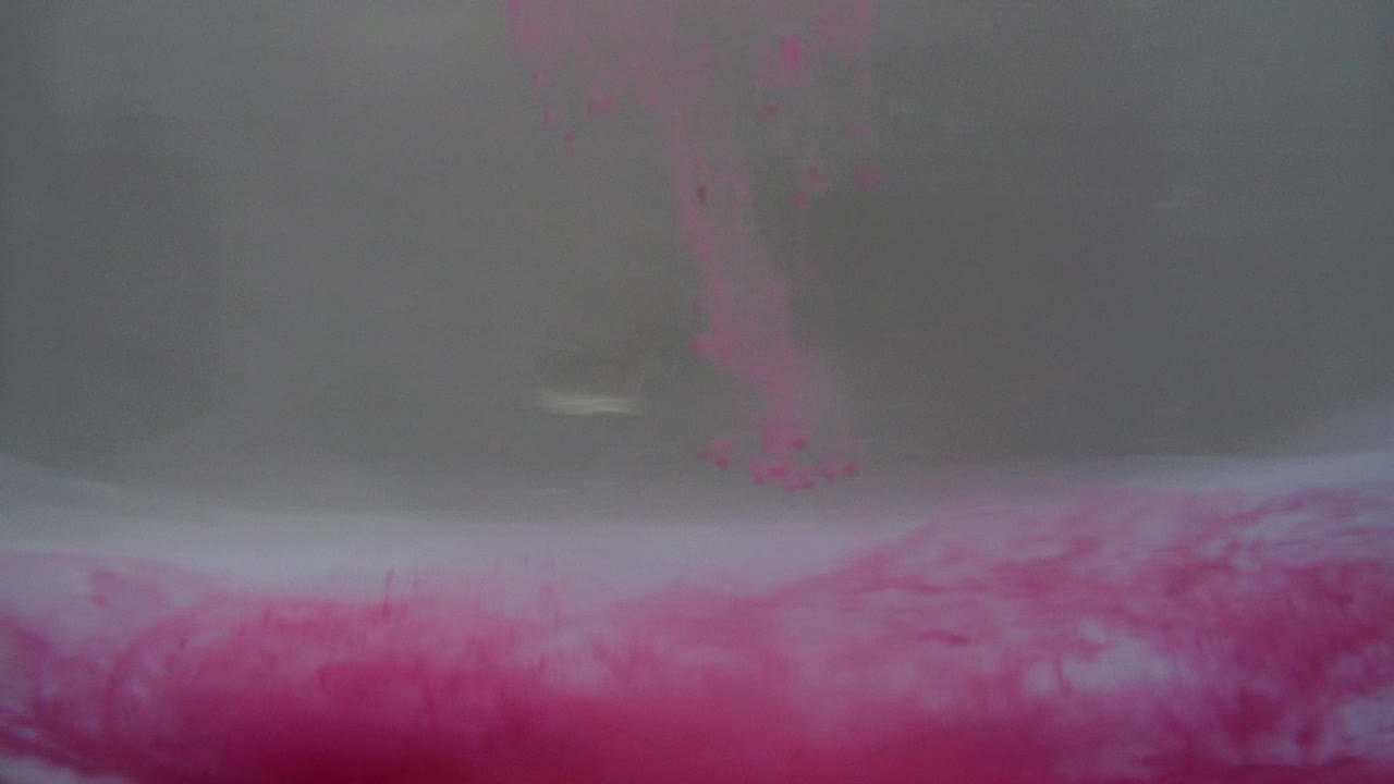 Pink and Purple Dye Swirling in Water