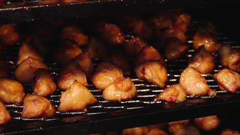 a large batch of golden-brown smoked chicken wings arranged on a grill rack. the wings appear juicy and well-cooked, ideal for barbecue or party servings.