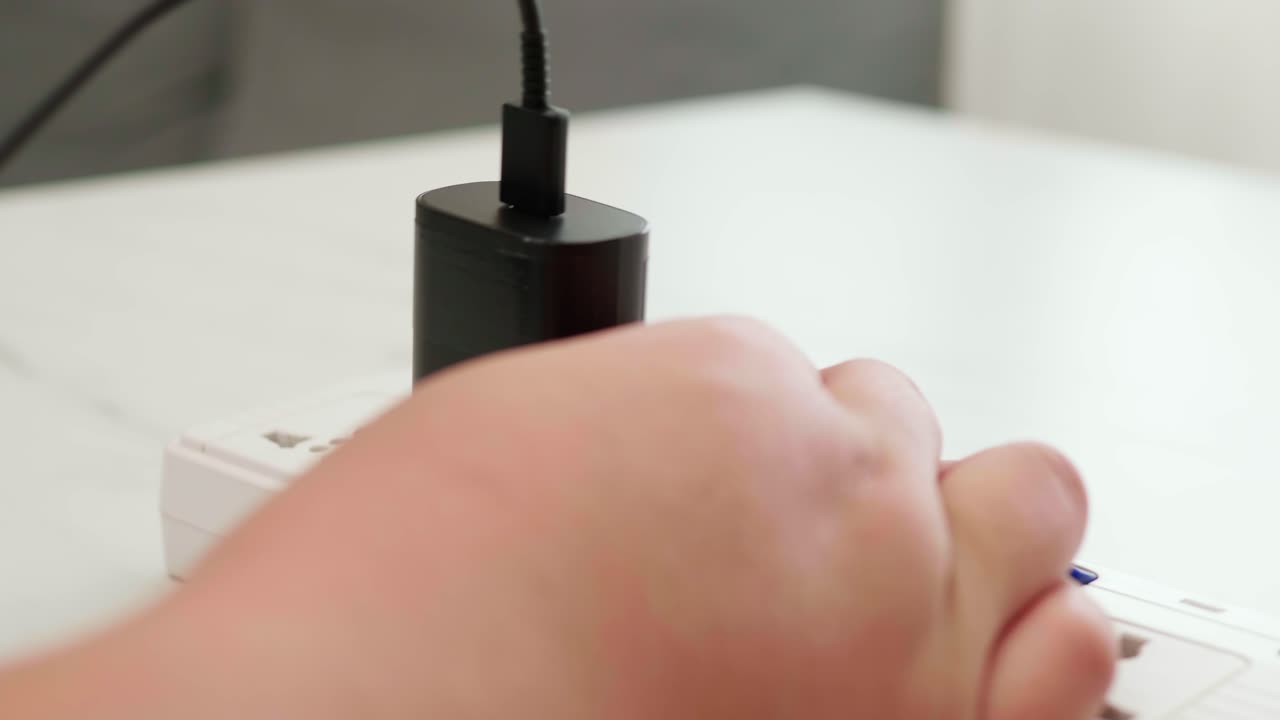 남자 손을 닫고 전화 어댑터 배터리를 뽑고 충전기를 제거하여 스위치를 끕니다.