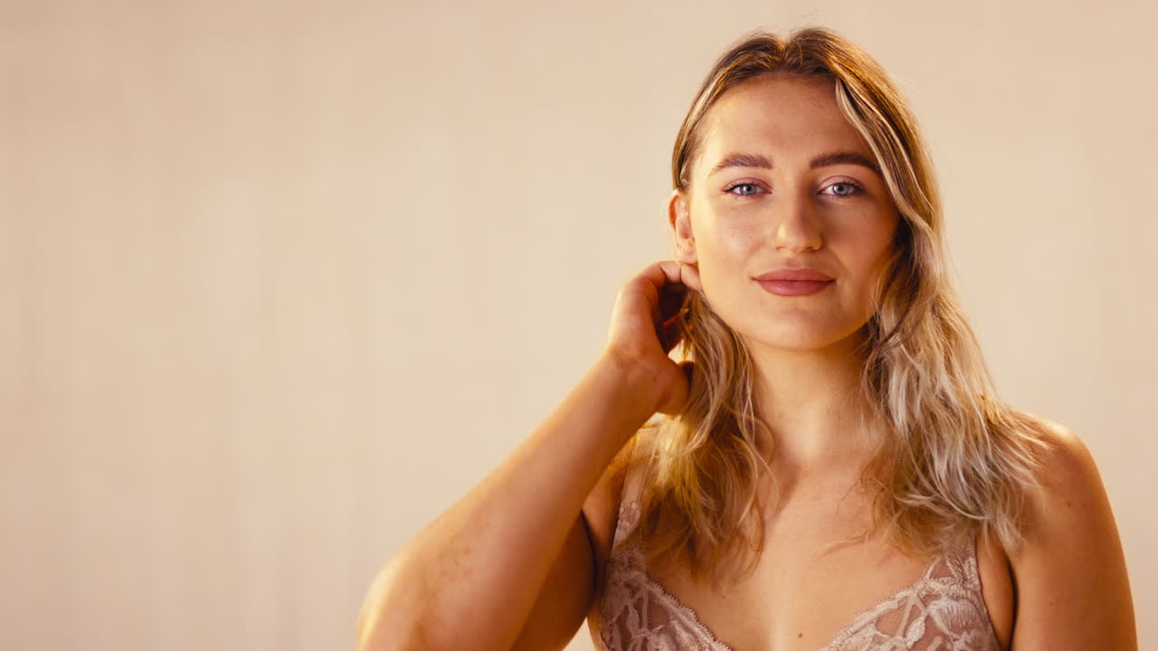 Scatto in studio di una donna sicura di sé che ride naturalmente, in intimo, promuovendo la body positivity