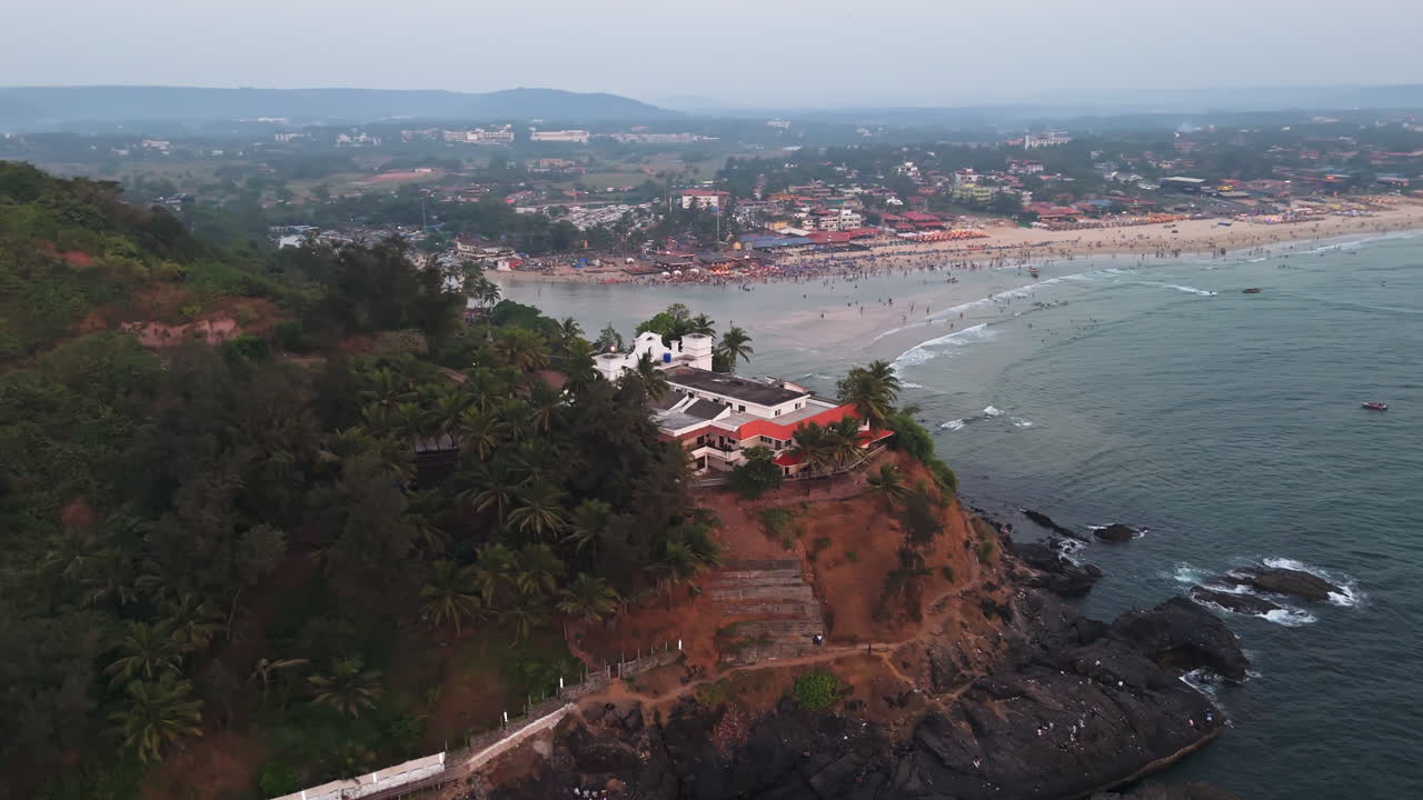 Panoramic drone shot around the Baga viewing point, hazy sunset in Goa, India