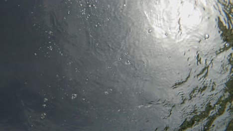 salpicaduras creando pequeñas burbujas y ondas en la superficie del agua de paralia emplisi, grecia europa- toma estática