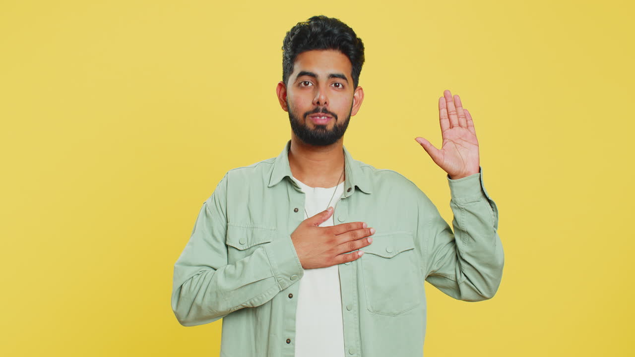 hombre indio levantando la mano para tomar juramento, prometiendo ser honesto y decir la verdad manteniendo la mano en el pecho