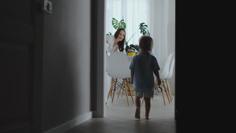 mom helps sons learn to draw doing homework preschool preparation at home sitting in the white kitchen. two brothers draw a portrait of mom together