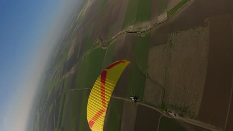 formato vertical: descensos aéreos más allá del dosel amarillo del parapente