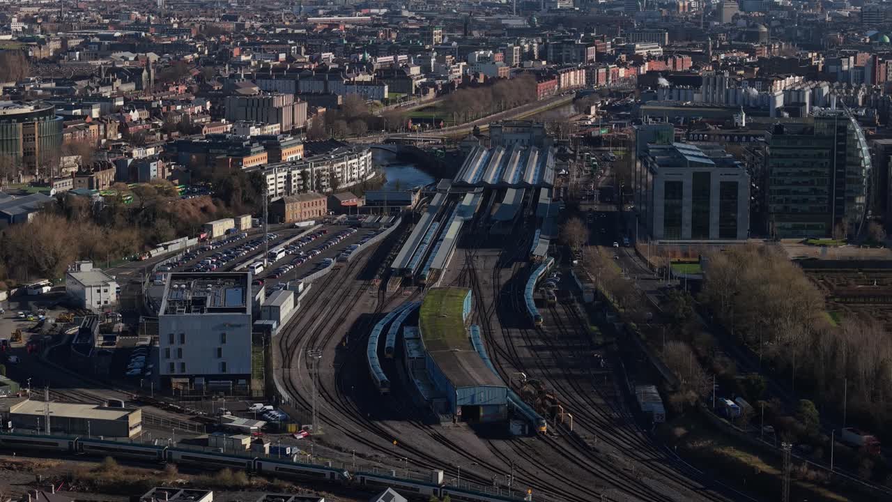 Dublin cityscape with Heuston train station, tracks, and urban skyline in sunlight