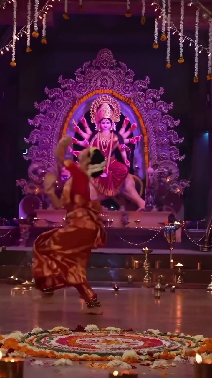 Graciosa dançarina clássica indiana apresentando-se diante de um ídolo da Deusa Durga