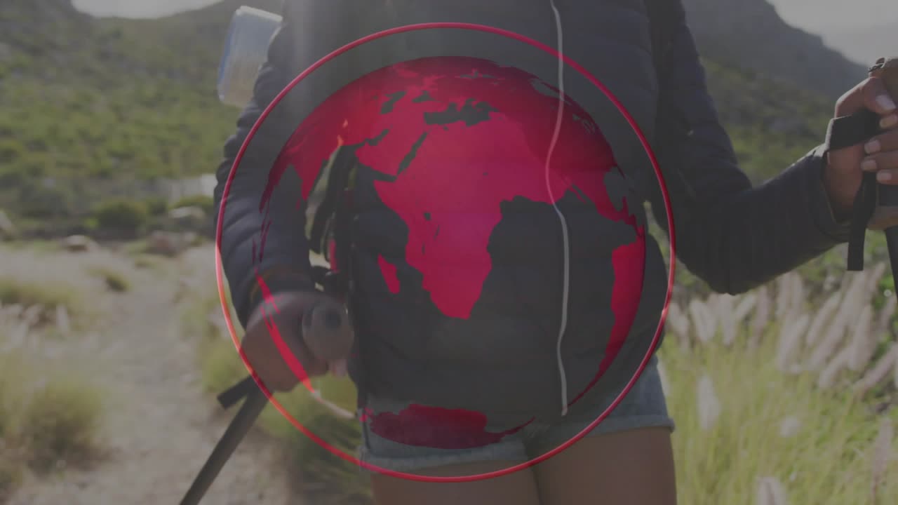 Donna che fa escursioni, iniziando piantando i bastoncini, con un globo rosso animato che ruota sul busto sincronizzandosi con i passi.