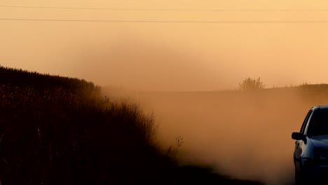 car driving on the dusty road in firmat, santa fe province in argentina at dusk - medium shot