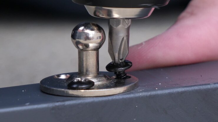 Close-up of cordless screwdriver turning screw into metal