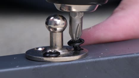 close-up of cordless screwdriver turning screw into metal