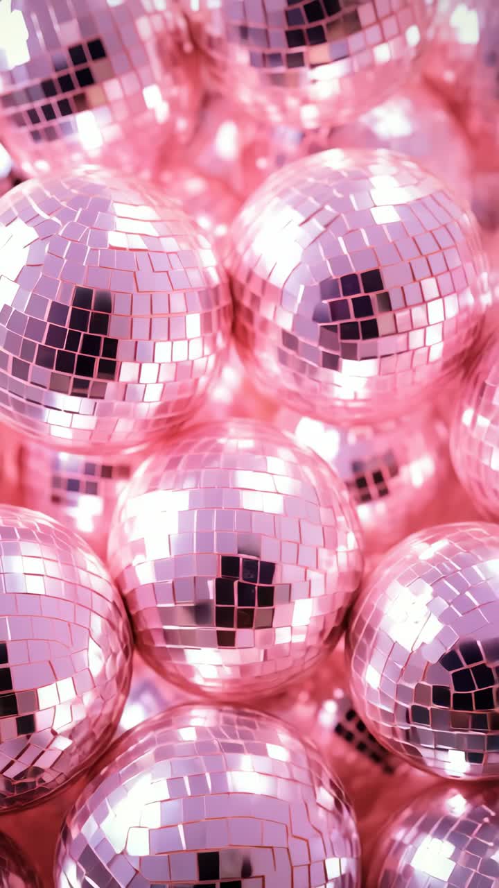 Close-up shot of pink disco balls reflecting light, creating a vibrant, festive atmosphere