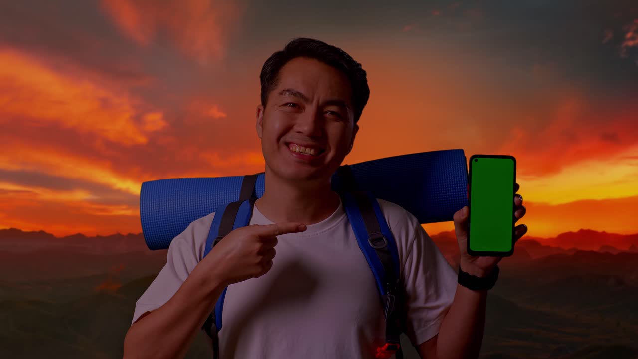 해가 지면 드폰을 보여주는 행복한 여행자